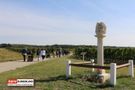 Gruppe auf dem Weg mit Dreifaltigkeitssäule im Vordergrund