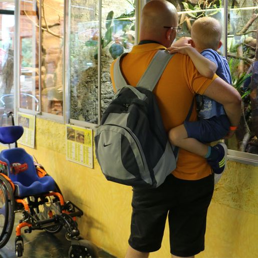 Mann mit Kind vor Terrarium