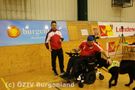 E-Rolli Fahrer mit Assistenzhund am Spielfeldrand