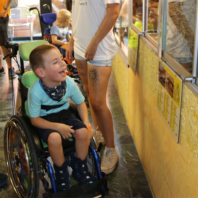 Bub im Rollstuhl vor Terrarium