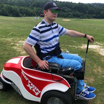 Mensch mit Behinderung im speziellen E-Rollstuhl für Golf