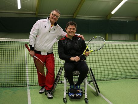 Eine behinderte Person und eine nichtbehinderte Person mit Tennisschläger 